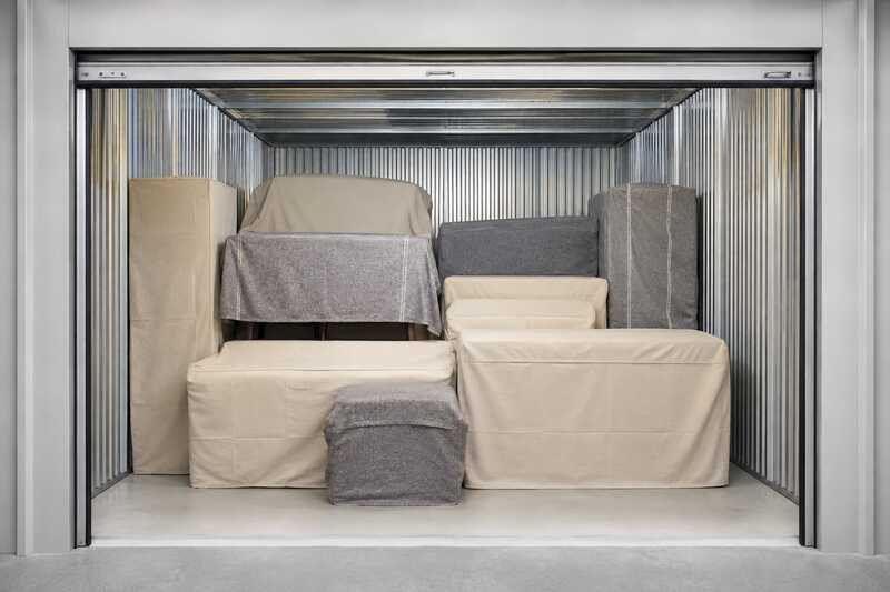 Box de garde-meuble ouvert sur du mobilier housse empilé